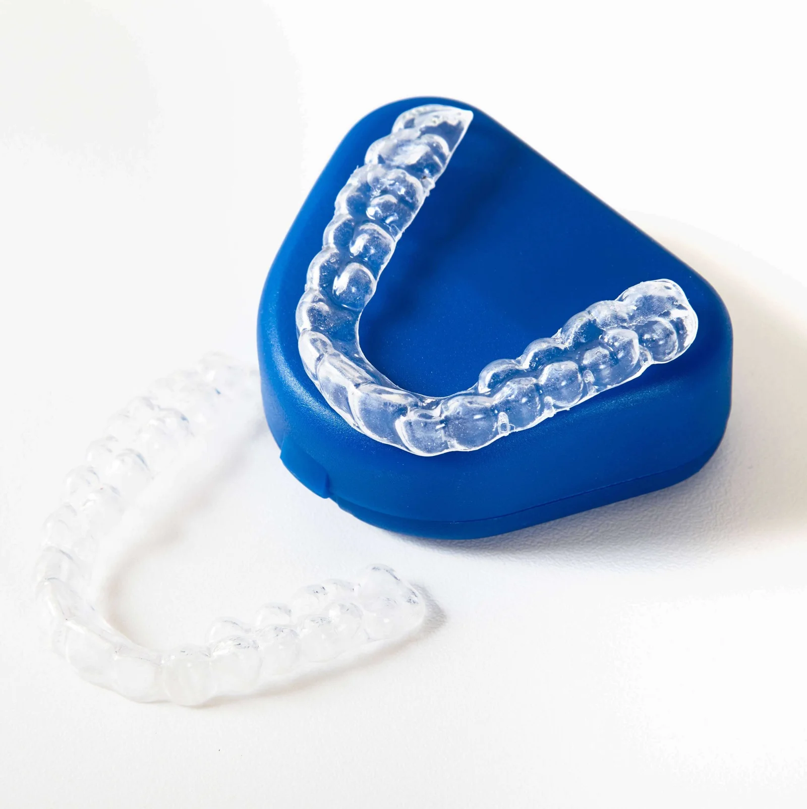 Par de alinhadores invisíveis transparentes sobre estojo azul, solução moderna de ortodontia estética na Felice Odontologia.